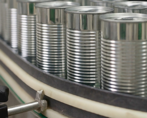 The image illustrates canned food on the manufacturing line.